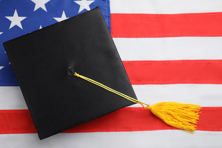 Black graduation hat on national USA flag, top viewの写真素材