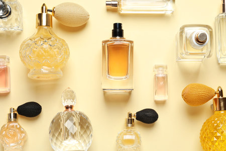 Flat lay composition with different perfume bottles on light yellow backgroundの写真素材