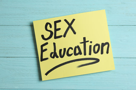 Note with phrase "SEX EDUCATION" on light blue wooden background, top viewの写真素材