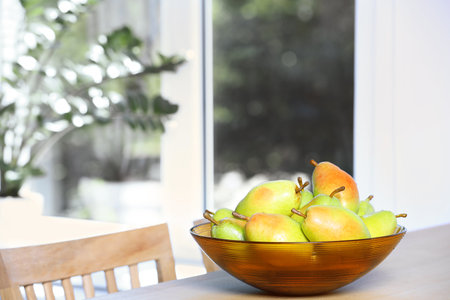 Fresh ripe pears on wooden table indoors. Space for textの写真素材