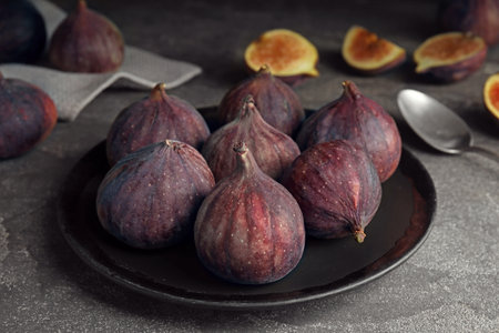 Plate with ripe figs on gray tableの写真素材