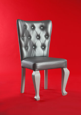 Stylish silver chair on red background. element of interior designの写真素材