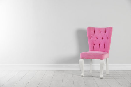 Stylish pink chair near white wall. Space for textの写真素材
