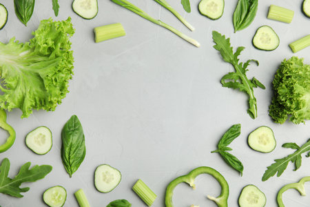 Flat lay composition with fresh salad ingredients on gray background, space for text
