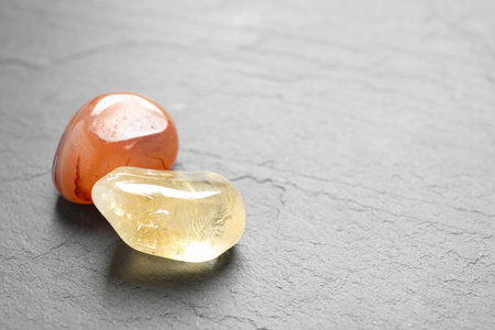 Orange gemstones on gray table, space for textの写真素材
