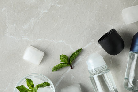 Flat lay composition with roll-on deodorants on light gray marble table