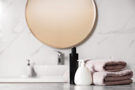 Folded towels and toiletries on marble table in bathroom, space for textの写真素材