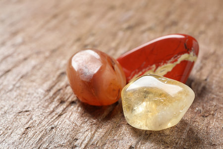 Beautiful red and white jade, carnelian agate and citrine quartz gemstones on textured surfaceの写真素材