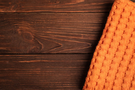 Orange kitchen towel on wooden background, top view. Space for textの写真素材