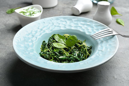 Tasty cooked spinach on gray table. Health foodの写真素材
