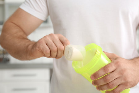 Man preparing protein shake in kitchenの写真素材