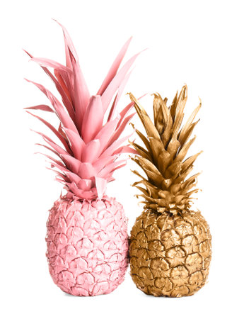 Gold and pink painted fresh pineapples on white backgroundの写真素材