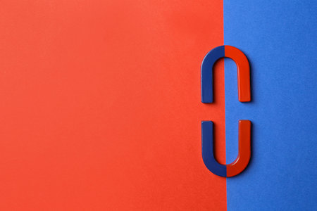 Red and blue horseshoe magnets on color background, flat lay. Space for textの写真素材