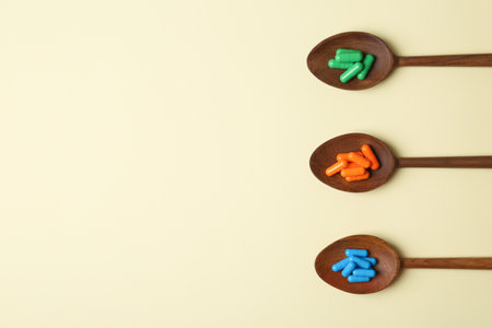 Wooden spoons with different pills and space for text on color background, top viewの写真素材