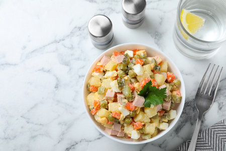 Delicious salad Olivier on marble table, flat lay. Space for textの写真素材