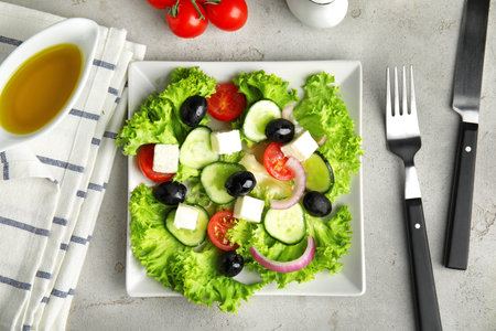 Tasty fresh Greek salad on gray table, flat layの写真素材
