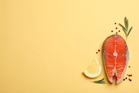Flat lay composition with salmon steak on yellow background. Space for textの写真素材