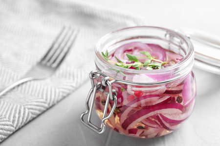 Jar of pickled onions on gray tableの写真素材