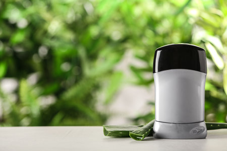 Deodorant container and aloe vera on white wooden table against blurred background. Space for textの写真素材