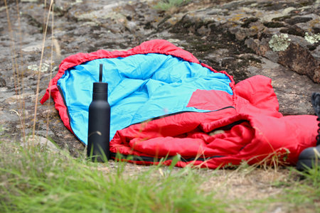 Sleeping bag and bottle outdoors. camp gearの写真素材