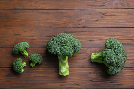 Flat lay composition of fresh green broccoli on wooden table, space for textの写真素材
