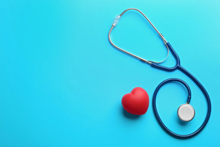 Stethoscope and red heart on blue background, flat lay with space for textの写真素材