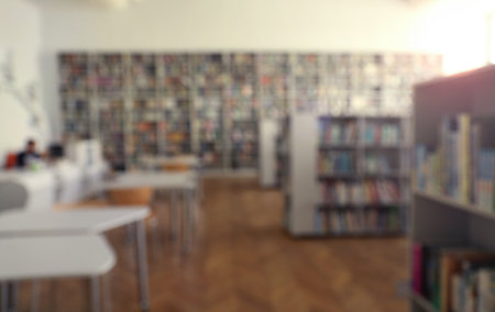 Blurred view of library interior with bookcases and tablesの写真素材
