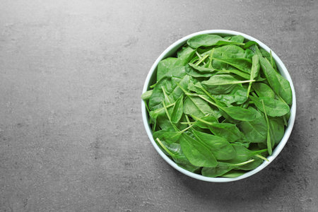 Fresh healthy green spinach on gray table, top view. Space for textの写真素材