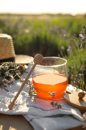 Jar of honey on wooden table in lavender fieldの写真素材