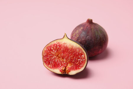 Tasty fresh fig fruits on light pink background