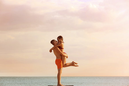 Young woman in bikini spending time with her boyfriend on beach. Lovely coupleの写真素材