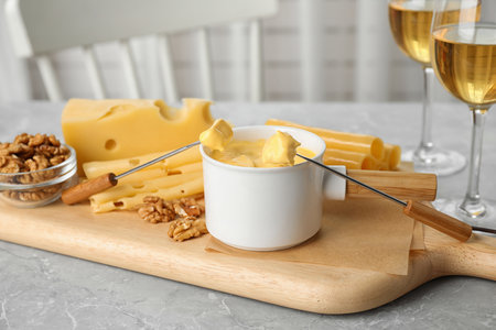 Pot of tasty cheese fondue served on gray table indoorsの写真素材