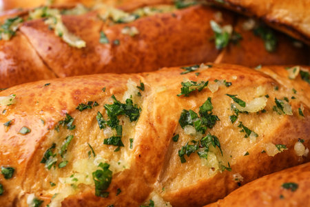 Bread loaves with garlic and herbs as background, closeup