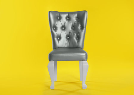 Stylish silver chair on yellow background. element of interior designの写真素材