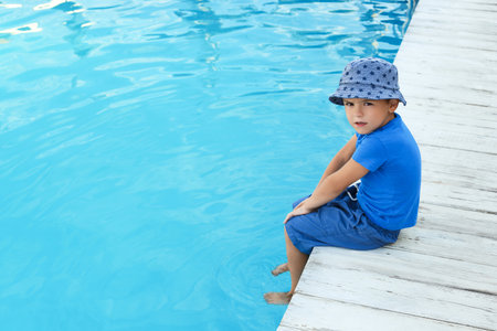 Little child near outdoor swimming pool. Dangerous situationの写真素材