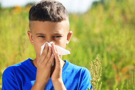 Little boy suffering from ragweed allergy outdoorsの写真素材