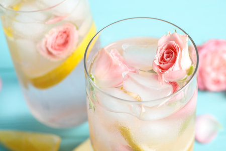 Tasty refreshing lemon drink with roses on light blue table, closeupの写真素材