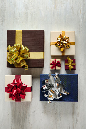 Flat lay composition with beautiful gift boxes on white wooden table