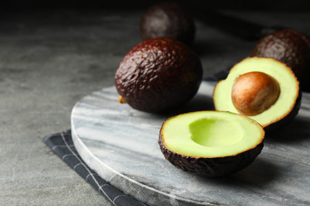 Delicious fresh ripe avocados on gray table
