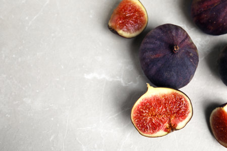 Tasty ripe figs on light gray marble table, flat lay. Space for textの写真素材