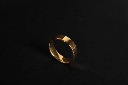 Beautiful gold wedding ring on black backgroundの写真素材