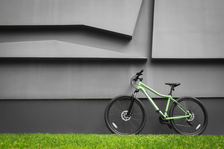 New modern color bicycle near dark gray wall outdoorsの写真素材