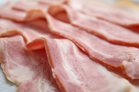 Slices of fresh raw bacon, closeup view