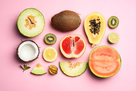Flat lay composition with tasty melon and fresh tropical fruits on pink backgroundの写真素材