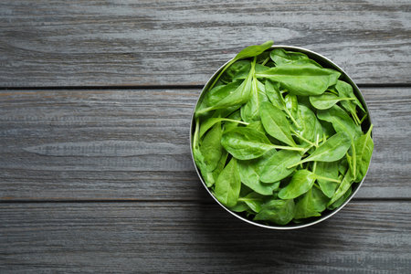 Fresh healthy green spinach on dark wooden table, top view. Space for text