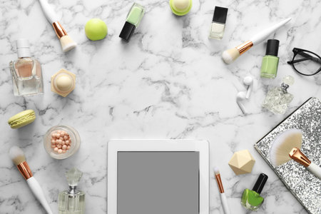 Frame made with tablet and beauty blogger's accessories on marble table, top viewの写真素材