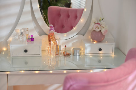 Elegant dressing table with lights and pink chair in stylish room interiorの写真素材