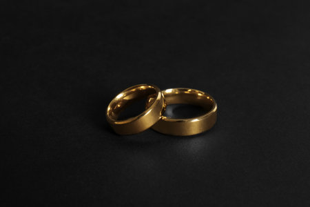 Elegant gold wedding rings on black backgroundの写真素材