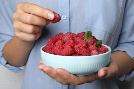 Woman holding bowl with delicious ripe raspberries, closeupの写真素材