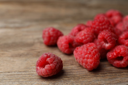 Heap of delicious ripe raspberries on wooden table, closeupの写真素材